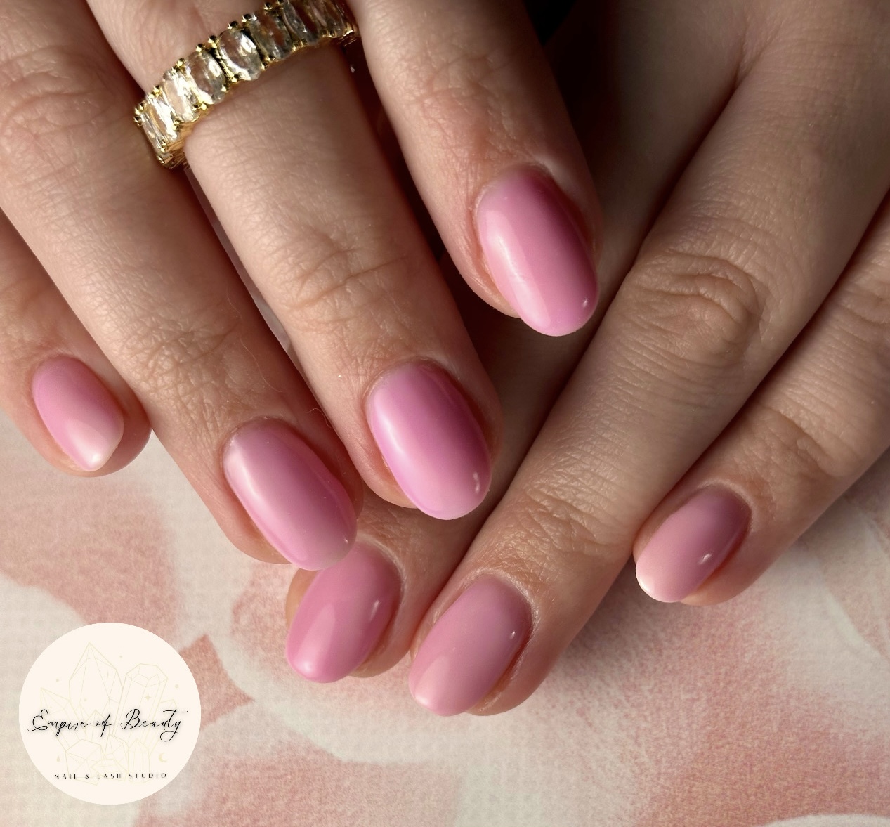 Glanzende roze gelnagels met een ring
