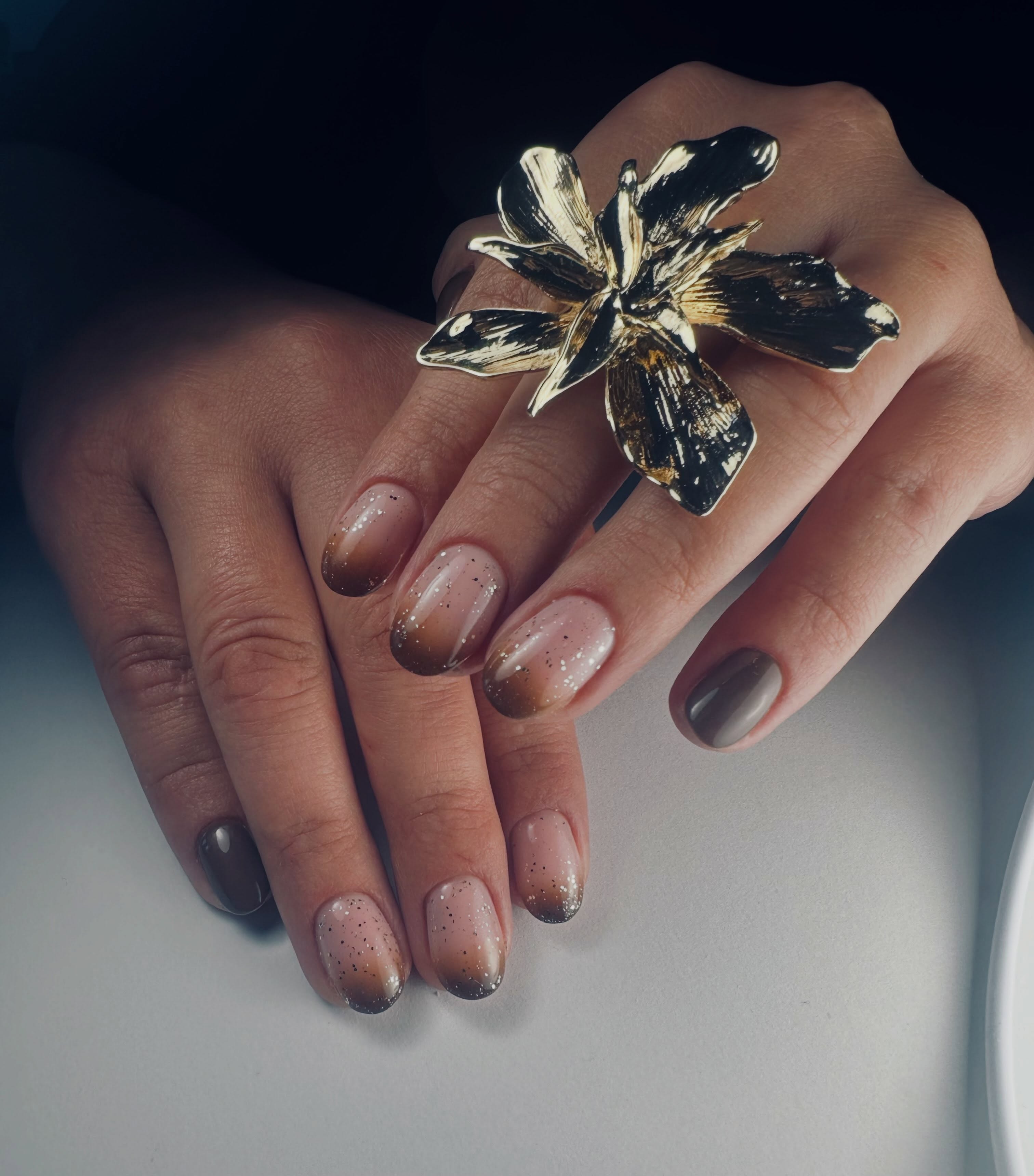 Nagels in warme chocoladetinten en nude met een subtiele sparkle